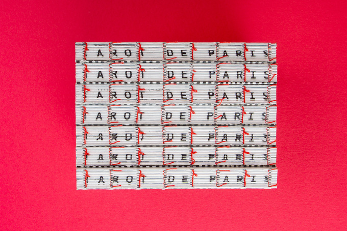 Text am Rücken einer offenen Fadenheftung mit roten Fäden