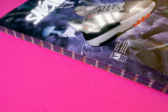 Rückenansicht einer offenen Fadenheftung mit buntem Faden im Rücken